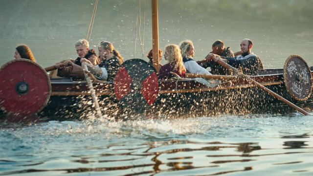 Medieval Ship with Vikings on Board Sails in the Middle of the River in a Magical Fog to new Shores. Concept of Romanticism.