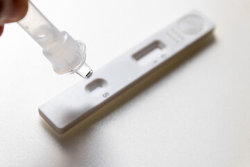 Antigen test sample being dropped onto medical device for covid-19 antigen self test. Coronavirus infection detection kit.