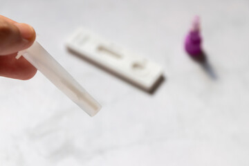 Hand holding Rapid Antigen Test kit with negative result swab COVID-19 testing. 