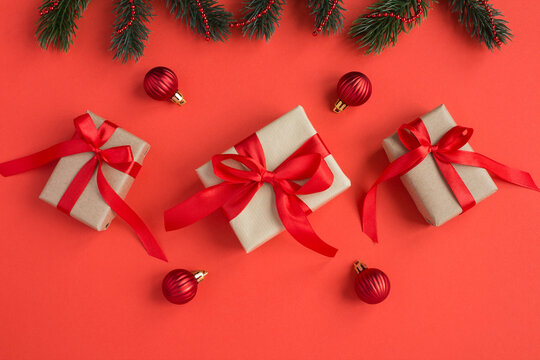Top view of  Christmas gifts with tiew red bow on the red background. Close-up.