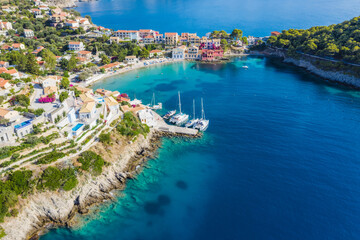 Fototapeta na wymiar Assos picturesque fishing village from above, Kefalonia, Greece. Aerial drone view. Sailing boats moored in turquoise bay