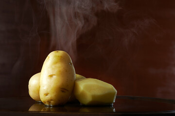 Batatas cozidas e quentes em fundo escuro