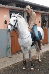 female rider in the stables mounted on horseback before going out for a jog