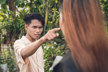An irate Filipino man accuses his girlfriend of infidelity. Scolding and berating her. Outdoor...