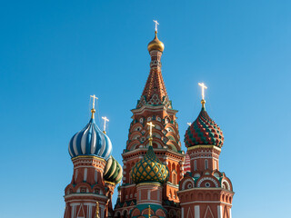Fototapeta na wymiar The bright domes of St. Basil's Cathedral against the blue sky. Red Square, Moscow, Russia.