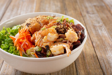 A view of a bowl of Vietnamese vermicelli noodles, also known as bún, featuring shrimp and marinated beef.