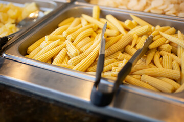 A view of a steamer pan filled with baby corn, seen at a local buffet restaurant.