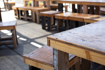 A closeup view of a Vietnamese cafe patio area featuring small tables and chairs.