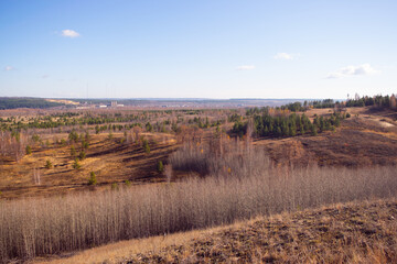 A village in the distance behind an autumn forest