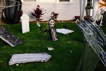 The front lawn is decorated with skeletons, graves and ghosts for the Halloween celebration. Halloween background