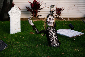 The front lawn is decorated with skeletons, graves and ghosts for the Halloween celebration. Halloween background