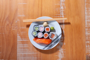 Top view of a white plate with some sushis and a sashimis