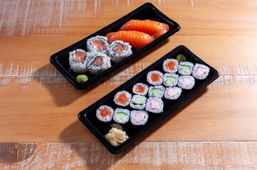 Two sushi bar with nigiris and hossomakis on a wooden table