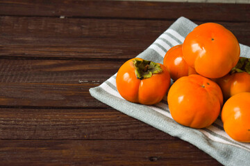 orange persimmon lies on a wooden background. still-life