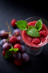 Fresh smoothie in a glass. Dark background. Close up. 
