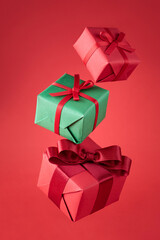 Flying gifts in multicolored packaging on a red background, gifts for Christmas holidays.