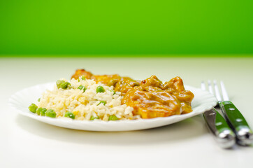 Chicken curry with egg fried rice, chicken breast pieces in a mildly spiced coconut curry sauce with fried rice with peas and egg