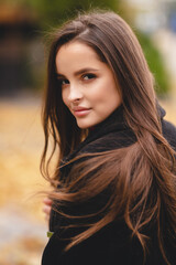 Fototapeta premium Autumn portrait of an attractive girl. Autumn shades. Stylish girl relaxes in warm autumn