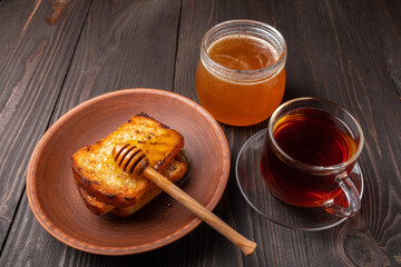 cup of black tea, jar of honey and slices of bread