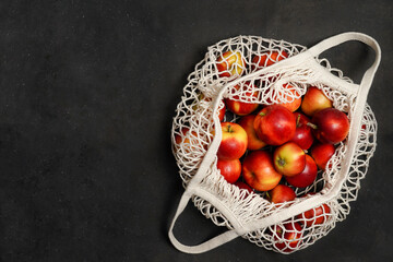 Apples starking in the mesh bag. Sustainability and conscious consuming concept. Top View. Flat Lay. Free space for text.