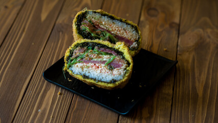 Sushi bomb. Creative Japanese food. A bomb made with rice, seafood and nori. the bomb is cut in two to show all the ingredients.