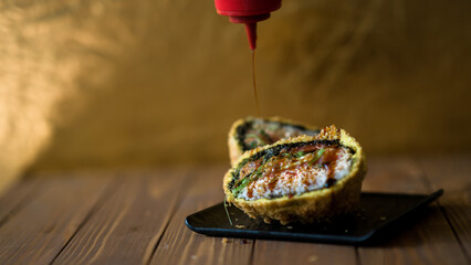 Sushi bomb. Creative Japanese food. A bomb made with rice, seafood and nori. the bomb is cut in two to show all the ingredients.