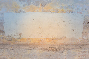 Old cracked abandoned shabby grunge yellow stucco plastered wall with fresh painted frame with copy space for text