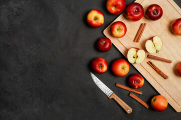 Fresh red apples with cinnamon on a black background. Apple baking seasonal concept. Fruits. Top view. Free space for text.