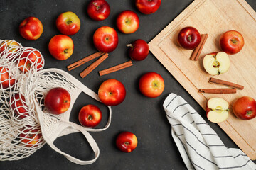 Fresh red apples with cinnamon on a black background. Apple baking seasonal concept. Fruits. Top view. Free space for text.