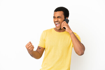 African American handsome man using mobile phone over isolated white background celebrating a victory