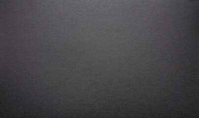 The paper background is black. Gloomy background for the text. The texture of dark cardboard.