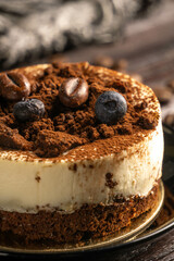 Cake with coffee beans and blueberry on the dark wooden backdrop 