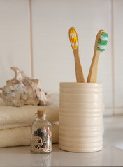 Cockleshell, Bath white cotton towels and bamboo toothbrushes on Blurred bathroom interior background with sink and faucet
