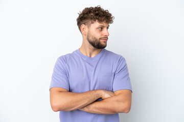 Young handsome caucasian man isolated on white background keeping the arms crossed