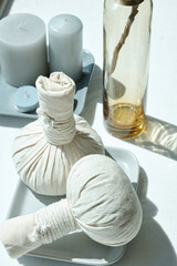 Two textile bags with aromatic herbs and group of candles ready for relaxing thai massage