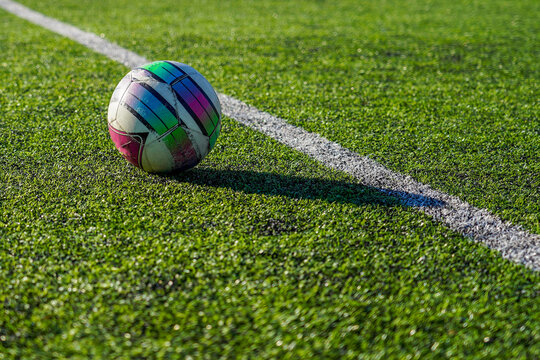 Photo of the ball on the green lawn of the football field on the street