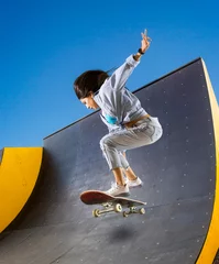 Abwaschbare Fototapete Skateboarder doing a jumping trick © Andrey Burmakin