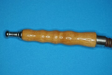 one brown wooden pipe on the hookah hose lies on a blue table