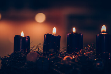 four black burning candles on advent wreath, dramatic and contract