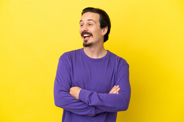 Young caucasian man isolated on yellow background happy and smiling