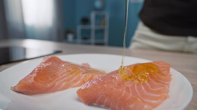 The process of marinating salmon fish when it is watered with honey. Slow motion video of cooking healthy vegetarian food.