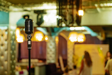 Retro style of microphone on restaurant background. Vintage professional musical equipment.