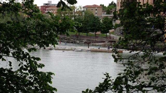 Kayak training in the dora river in Ivrea. Frame of trees. Slow motion 4K