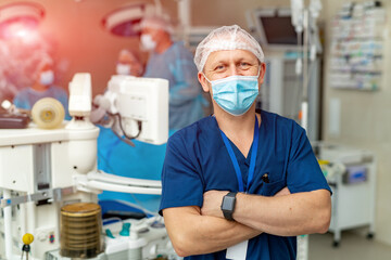 Male surgeon looking at camera at hospital. Professional surgery doctor in mask.
