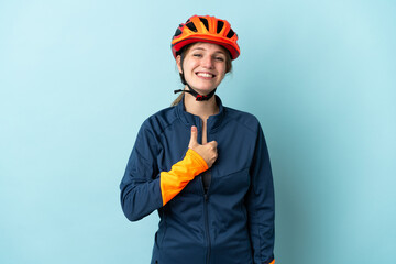 Young cyclist woman isolated on blue background giving a thumbs up gesture
