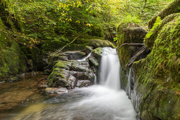 Long exposure of a waterfall on the Hoar Oak Water river flowing through the woods at Watersmeet in Exmoor National Park