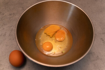 Broken chicken eggs in a metal omelet bowl