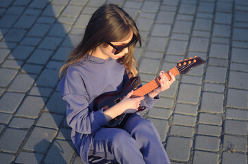 child playing guitar in the street