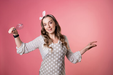 young charming pastry chef woman with a whisk in her hands.