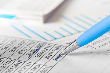 Accounting document with pen,color diagram and checking financial chart. Concept of banking, financial report and financial audit. In blue color.